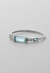 Sterlingsilberring mit einem rechteckigen, hellblauen Edelstein in der Mitte, flankiert von kleineren hellblauen und klaren Steinen in einem minimalistischen Design.
