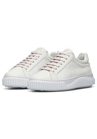 Sneaker in pelle bianca con suola in gomma bianca testurizzata, lacci rosa chiaro a contrasto e dettagli di cucitura decorativa sul lato.