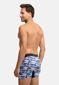 Blå och vita kamouflagemodellerade badshorts med svart midja och sidoflik. Mjuk, elastisk material som är utformad för komfort och hållbarhet.