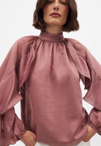 Roze satijnen blouse met een hoge hals, ruches aan de mouwen en geplooide details. Glad textuur en een losse pasvorm, met elastische manchetten.