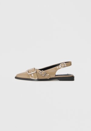 Beige patent slingback shoes with a pointed toe, two adjustable buckles, and a low black heel. Smooth texture with a glossy finish.