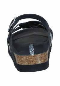 Schwarze Sandale mit Korksohle, verstellbaren Riemen und strukturiertem Fußbett. Verfügt über ein glattes, langlebiges Obermaterial und ein minimalistisches Design.