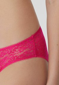 Spitzenunterwäsche in leuchtendem Pink, mit floralen Mustern, gewellten Rändern und einer weichen, strukturierten Oberfläche, entworfen für Komfort und Stil.