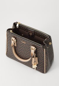 Sac à main à motif marron avec quincaillerie dorée, accents crème, fermeture éclair et doubles poignées. Matériau texturé avec un design géométrique.