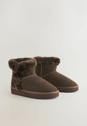 Ruske nubuk ankle boots med faux fur krage. Designet har en flad sål og syninger, der giver et hyggeligt udseende.
