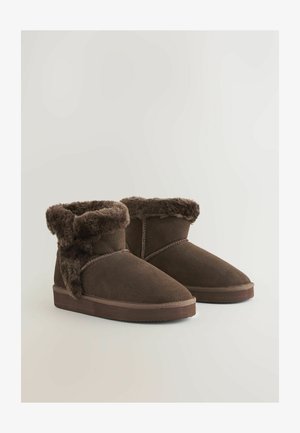 Ruske nubuk ankle boots med faux fur krage. Designet har en flad sål og syninger, der giver et hyggeligt udseende.