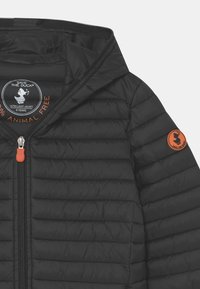 Svart vadderad lättviktsjacka med huva, framsida med dragkedja och orange "Save The Duck" logotyp på ärmen och inuti etiketten.