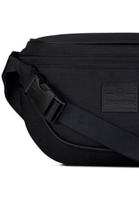 Svart axelväska i slitstarkt tyg, med en smidig dragkedja, justerbar rem och rektangulär form med en logopatch.