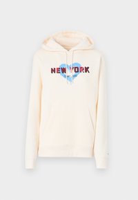 Sudadera crema con bolsillo frontal, cordones y texto "NEW YORK" sobre un gráfico de corazón azul, "Tommy Jeans" debajo del texto.