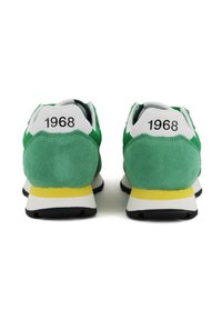 Sneakers in suede verde e grigio con dettagli gialli, dotati di un tallone bianco e la scritta "1968" stampata sul retro. Suola in gomma nera.
