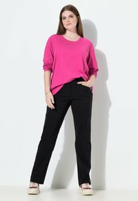 Magenta shirt met lange mouwen, zwarte broek met rechte pijpen en witte sneakers. Soepele stof met een ontspannen pasvorm en een eenvoudig ontwerp.