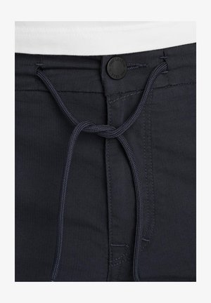 Morski kopalni hlače z vrvico za prilagajanje in črnim označenim gumbom v pasu. Gladka tekstura z diskretnimi šivi.