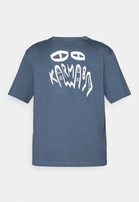 Blue cotton t-shirt features a white graphic design on the back, including eyes and the word "KARMA" in artistic lettering. Short sleeves.