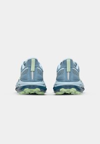 Running shoes with a light blue mesh upper, reflective accents, and a textured green outsole. Thick cushioning for enhanced support.
