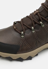 Brown hiking boot featuring a textured leather upper, mesh accents, metal eyelets, and a durable rubber outsole with traction lugs.