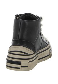 Schwarzer High-Top-Sneaker aus Leder mit einer klobigen beige-farbenen Sohle, die schwarze Streifen, strukturiertes Design und eine Schnürung an der Vorderseite aufweist.