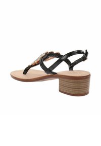 Sandal nera con cinturini e tacco a blocco, dotata di suola texturizzata ed elementi decorativi sulla tomaia, realizzata in materiali sintetici.