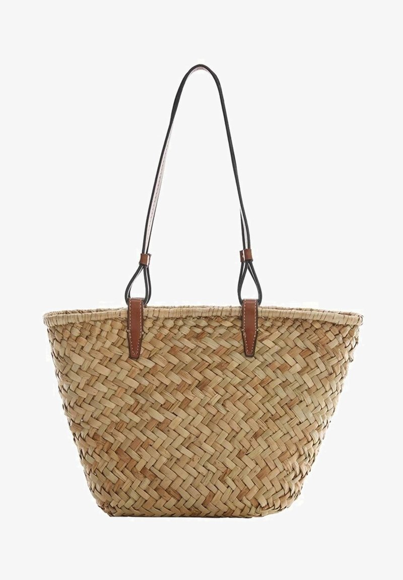 Sac fourre-tout en paille tressée avec une large ouverture en haut et de longues bretelles fines noires attachées par des patchs en cuir marron.
