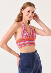Top crop all'uncinetto con scollo a halter, caratterizzato da strisce vivaci arancioni, rosa e viola, con un profondo scollo e una silhouette aderente.