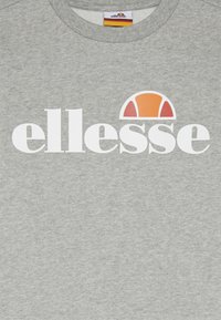 Szara bluza wykonana z bawełnianej mieszanki materiałów, z dużym białym napisem "ellesse" oraz okrągłym logo w kolorach pomarańczowym i żółtym nad napisem.