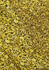 Tissu jaune avec un petit motif floral dense en noir et blanc, comprenant une section matelassée texturée avec des coutures diagonales.