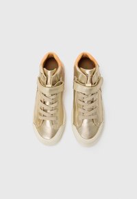 High-Top-Sneaker in metallischem Gold, mit einem Akzent aus beige Leder, flachen Schnürsenkeln und einem Klettverschluss über dem Knöchel für einen sicheren Sitz.