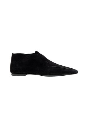 Chaussure plate noire en daim montant à la cheville, avec un bout pointu et des détails de couture minimalistes, vue de profil sur fond blanc.