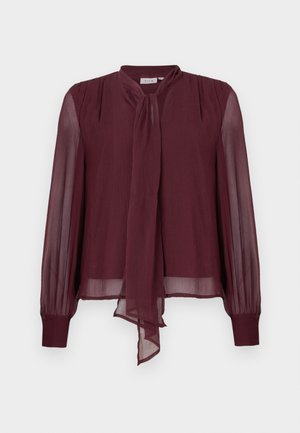 Blusa de gasa burdeos con mangas largas y transparentes, detalle de cuello atado y acentos plisados en los hombros. Corte relajado y textura semitransparente.