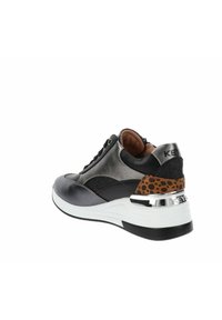 Sneakers mają czarną skórzaną cholewkę z metalicznymi srebrnymi akcentami, teksturowany brązowo-czarny punktowany obcas oraz masywną białą podeszwę.