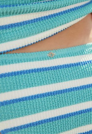 Sinine ja valge triibuline kootud kangas tekstuurse pinnaga ning väike kuldne detail ääres. Omab voltidega servasid ja erineva paksusega triibusid.