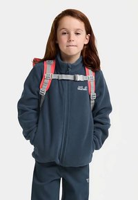 Dunkelblaue Fleecejacke mit hohem Kragen, Frontreißverschluss und Logo. Verfügt über graue und pinke, verstellbare Riemen für einen Rucksack.