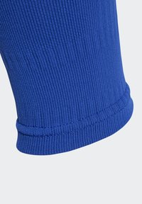 Blauwe ribstof met een gestructureerd oppervlak, voorzien van een gezoomde rand om rafelen te voorkomen. Ontworpen in een aansluitende, buisvormige stijl.