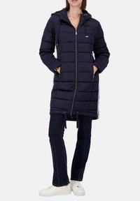 Marineblauer Puffermantel mit Kapuze, Reißverschluss vorne, seitlichen Taschen und Kordelzug an der Taille. Mit horizontalem Steppmuster und kontrastierenden seitlichen Streifen.