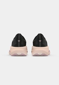 Zwarte sportieve schoenen met een gestructureerde bovenkant, roze tussenzool en contrasterende trekstrip; beschikt over een ronde hak en een uniek profiel van de buitenzool.