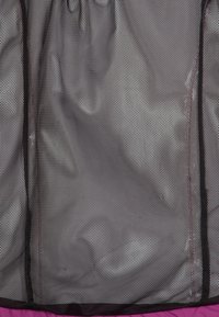 Svart nättyg med ett hexagonalt mönster, har synliga sömmar och en mjuk innerfoder. Designen är lätt och flexibel.