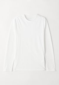 Hosszú ujjú, fehér póló, puha, könnyű anyagból készült. Kerek nyakkivágással és egyenes szegélyekkel rendelkezik. Nincs rajta minta vagy figyelemfelkeltő díszítés.