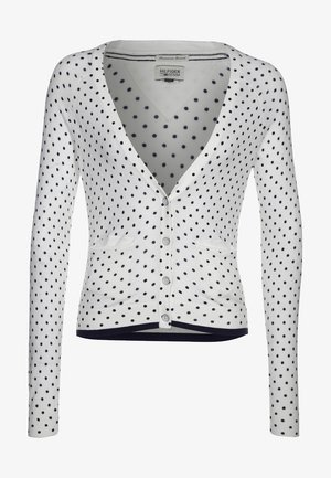 Cardigan blanc à pois bleu marine, col en V, manches longues, boutonné sur le devant, avec deux poches avant. Ourlet et poignets côtelés.