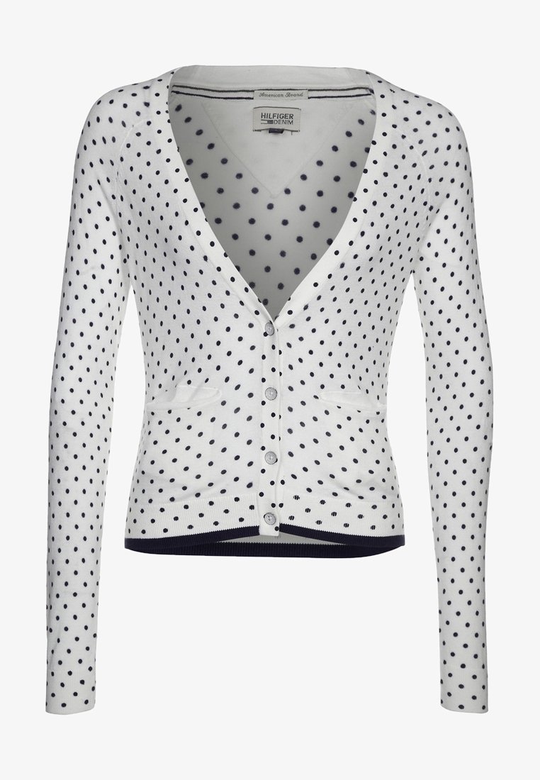 Vit cardigan med marinblå prickar, V-ringning, långa ärmar, knapplinje fram och två framfickor. Ribbad fåll och muddar.