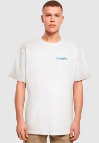 White cotton t-shirt featuring a blue graphic "27 Studios." Short sleeves, relaxed fit, and crew neckline with smooth texture.