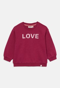 Bordeauxfärgad tröja med lång ärm, ribbad mudd och fåll. Har ordet "LOVE" i texturerade vita bokstäver på framsidan.