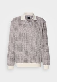Pull en maille à manches longues avec col, poignets et ourlet en maille crème, présentant un motif en zigzag texturé gris et marron.
