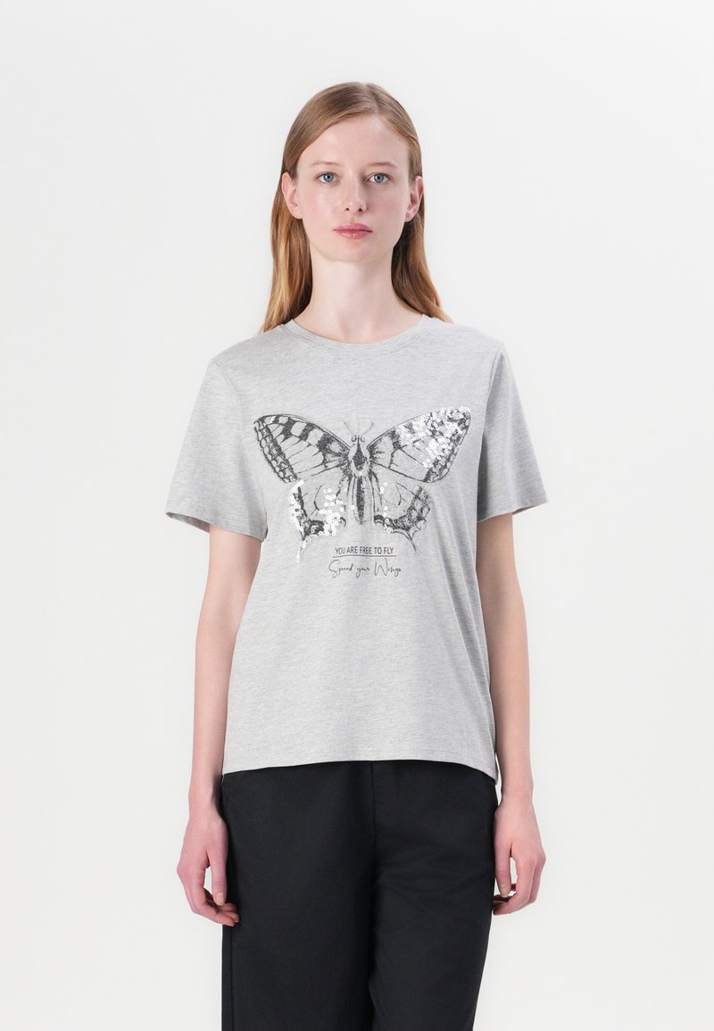 T-shirt en coton gris avec un grand motif de papillon orné de sequins, accompagné du texte "Vous êtes libre de voler" en lettres noires.
