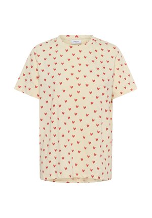 Lyhythihainen t-paita kermaista puuvillaa, jossa toistuva kuvio pienistä punaisista sydämistä. Pyöreä pääntie ja rento istuvuus.