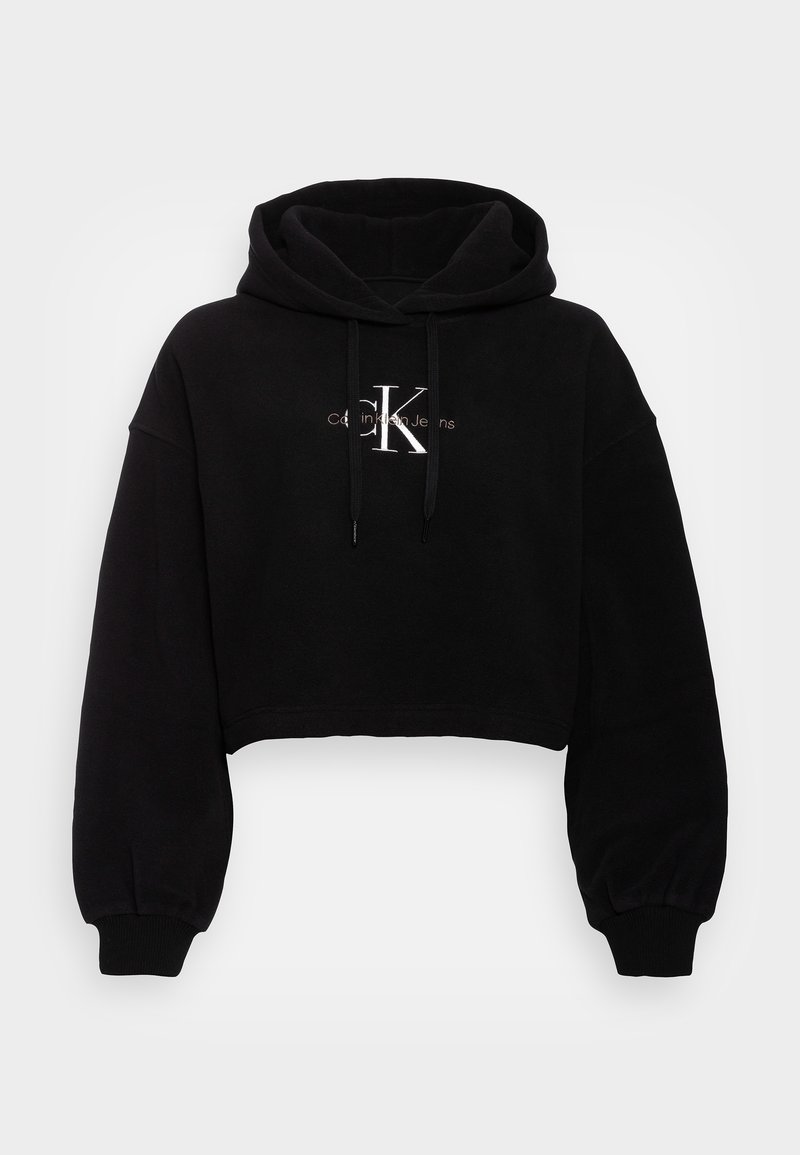 Felpa corta nera realizzata in tessuto morbido, con un ampio cappuccio, maniche lunghe e un logo frontale in filo argentato. Polsini e orlo a coste.