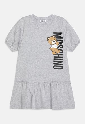 Grå bomulds kjole med korte pufærmer, med en bjørne grafik og ordet "MOSCHINO" i lodret sort tekst. Flæse detalje ved kanten.