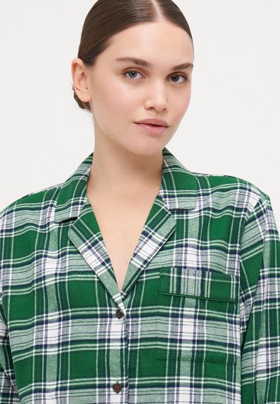 Green and white plaid button-up shirt featuring a collar, a pocket, and soft fabric texture. The pattern includes navy accents.