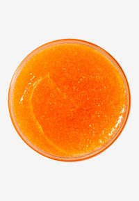 Klart orange gel i en rund glas skål, slät textur med fina partiklar synliga, reflekterar ljus. Inga ytterligare element närvarande.