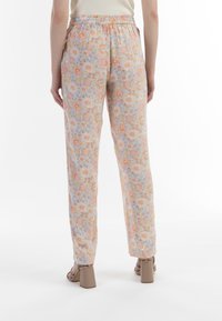 Bloemmotief broek met een lichtblauwe achtergrond, versierd met perzikkleurige, gele en groene bloemen, elastiche tailleband en een losse pasvorm.