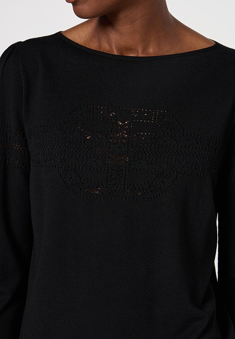 Schwarzer Strickpullover mit einem Boots-Ausschnitt, der ein transparentes, gemustertes Einsatz über der Brust und strukturierte Ärmel-Details aufweist.