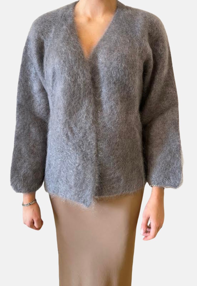 Grauer, flauschiger Cardigan mit V-Ausschnitt, langen Ärmeln und lockerer Passform. Aus weichem Material gefertigt, mit einem leicht unebenen Saum.